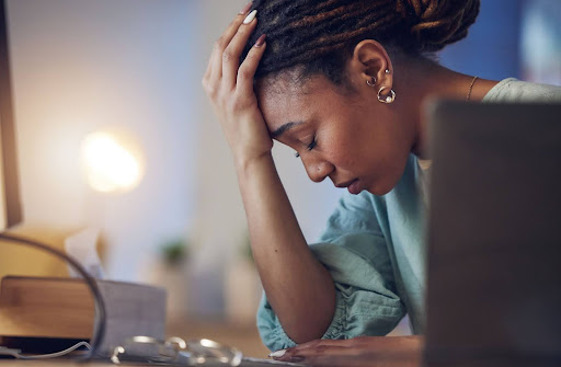 woman with her head in her hand due to stress